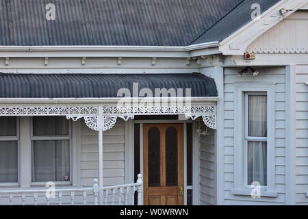 Dettaglio del classico in legno bianco villa con portico ornamentali e lamiera grecata tetto. Foto Stock