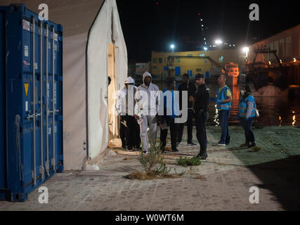 Malaga, Spagna. Il 28 giugno, 2019. I migranti stand al di fuori di una tenda della Croce Rossa spagnola dopo il loro arrivo al porto di Malaga.Spagna's Maritime Rescue service salvato 50 migranti a bordo di un battello che attraversa il Alboran Mare e li ha portati al porto di Malaga, dove sono stati assistiti dalla Croce Rossa spagnola. Credito: SOPA Immagini limitata/Alamy Live News Foto Stock