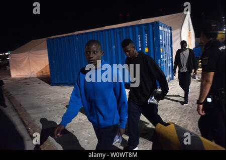 Malaga, Spagna. Il 28 giugno, 2019. I migranti lasciare una tenda della Croce Rossa spagnola come si cammina verso una polizia van dopo il loro arrivo al porto di Malaga.Spagna's Maritime Rescue service salvato 50 migranti a bordo di un battello che attraversa il Alboran Mare e li ha portati al porto di Malaga, dove sono stati assistiti dalla Croce Rossa spagnola. Credito: SOPA Immagini limitata/Alamy Live News Foto Stock