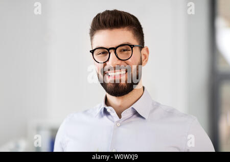 Ritratto di sorridente imprenditore barbuto in bicchieri Foto Stock