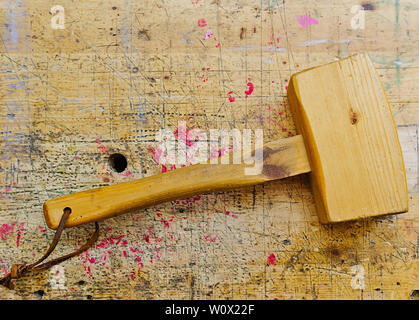 Macchine per la lavorazione del legno di antiquariato mazzuolo di legno martello isolati su invecchiato panca in legno grunge superficie. Foto Stock