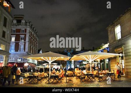 Londra/UK - Novembre 27, 2013: persone mangiare sotto le tende presso il Covent Garden catering esterni spazio durante le vacanze di Natale. Foto Stock