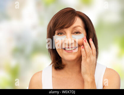 Felice donna senior con idrogel in sotto-eye patch Foto Stock