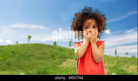 Confuso African American Girl bocca di copertura Foto Stock