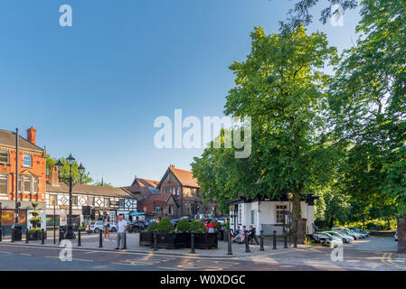 Il centro del villaggio di Woolton Liverpool su una serata estati wit ex convenienza pubblico trasformato in uffici ed ex Duck Pond ora un parcheggio auto. Foto Stock