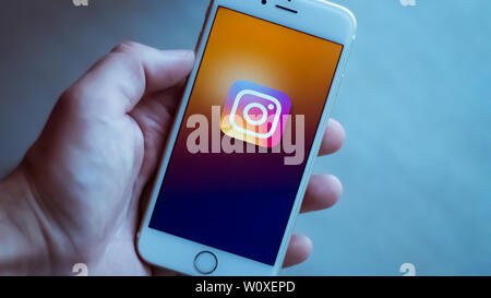 New York / Usa 06-27-2019: l uomo è in possesso di un bianco smartphone con l'icona del instagram rete sociale rappresentata. Foto Stock