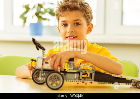 Avendo un hobby. Positivo ragazzo felice di essere in un buon umore mentre godendo il suo hobby Foto Stock