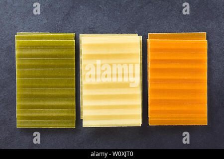 Materie tri color lasagne sfoglie di pasta, fotografato overhead su ardesia Foto Stock