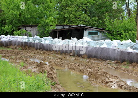 Una protezione antiesondazione temporanea parete realizzata con scatola di barriere e sacchi di sabbia coperte di fitti panno in geotessile e nylon utilizzato per proteggere case famiglia Foto Stock
