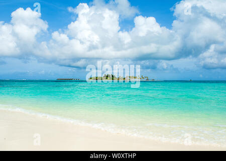 Lhaviyani Atoll, Maldive - 30 Luglio 2018: Windsurf Passeggiate nell'Oceano Indiano sullo sfondo con un isola tropicale paesaggistico e una spiaggia sabbiosa Foto Stock