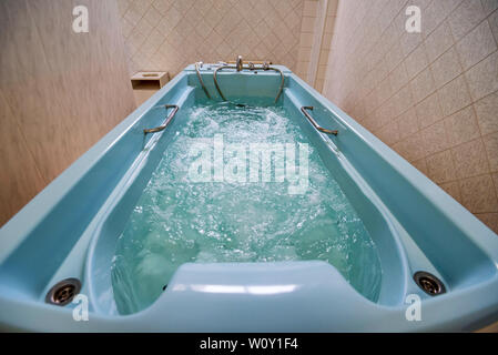 Vista di un moderno bagno Jacuzzi riempita con acqua attivata Foto Stock