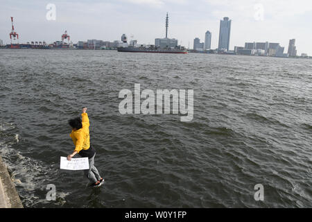 Tokyo, Giappone. Il 28 giugno, 2019. Un uomo Taiwanise può essere visto saltando in acqua fuori del Porto di Osaka Dimond punto come parte di una protesta simbolica contro il presidente cinese Xi Jinping che è stato in visita in Giappone. Lo stesso giorno la polizia e un elevato livello di sicurezza potrebbe essere visto di Osaka in Giappone durante la visita dei presidenti, primi ministri e altri alti dirigenti provenienti da tutto il mondo, che si sono riuniti per il vertice annuale del gruppo del G20 il 28 giugno 2019. Foto di: Ramiro Agustin Vargas Tabares Credito: Ramiro Agustin Vargas Tabares/ZUMA filo/Alamy Live News Foto Stock