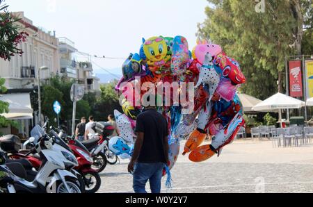 Un uomo vendita di cartoon palloni di elio sulla strada ad Atene in Grecia Foto Stock