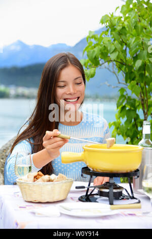 La Fonduta di formaggio - donna locale mangiando cibo svizzero. Persone mangiare cibo tradizionale dalla Svizzera divertimento dal lago delle Alpi sul viaggio in Europa. Foto Stock