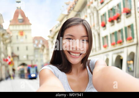 Donna prendendo selfie con smart phone a Berna Svizzera camminando sul Kramgasse, Berna Main Street nella città vecchia. Giovani femmine visitando le attrazioni turistiche e punti di riferimento. Foto Stock