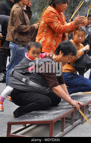 Adoratori bruciare incenso offerte presso il tempio buddista di Pechino Foto Stock