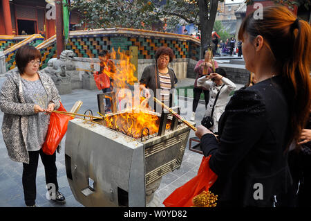 Adoratori bruciare incenso offerte presso il tempio buddista di Pechino Foto Stock
