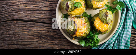 Zucchine ripiene di carne tritata, formaggio ed erbe verdi. Cotti in forno. Banner. Vista superiore Foto Stock