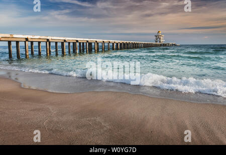 Cemento ponte a piedi in spiaggia al mare con cloud esterni illuminazione. Foto Stock