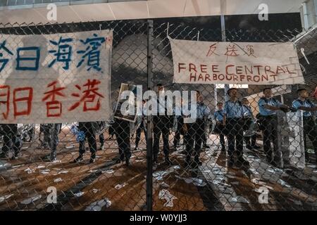 Gli ufficiali di polizia visto custodire l'appezzamento di terreno nel centro di Waterfront che per essere trasferiti ai cinesi Esercito del popolo. Protester ha messo su banner di anti trasferimento il Land messaggi sulla barriera.centinaia di manifestanti rally contro il governo di trasferimento di un appezzamento di terreno sul lungomare centrale per il popolo cinese della Esercito di Liberazione (PLA) come un militare di dock. Pro-democrazia dimostranti di Hong Kong hanno organizzato manifestazioni nelle scorse settimane, per chiedere il ritiro di un controverso disegno di legge in materia di estradizione, le dimissioni del territorio è chief executive Carrie Lam, un'indagine Foto Stock