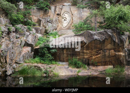 Rilievo monumentale "Bretschneider l orecchio' (Bretschneiderovo ucho) scolpito da scultore ceca Radomír Dvořák (2005) nella cava abbandonata vicino Lipnice nad Sázavou nella regione Oberland, Repubblica Ceca. Il rilievo è uno dei tre rilievi formanti il Monumento Nazionale di spionaggio (Národní památník odposlechu) situato in tre cave vicine. Agente di polizia Bretschneider è stato uno dei personaggi del famoso romanzo satirico il buon soldato Švejk dal romanziere ceco Jaroslav Hašek, che ha trascorso questi ultimi mesi della sua vita e morì in Lipnice nad Sázavou. Foto Stock