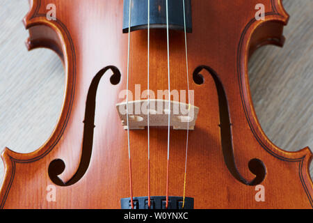 F fori di un violino che è giacente su un sfondo di legno Foto Stock