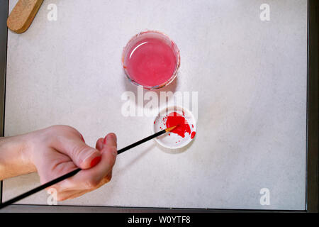 L'uomo pittore è la miscelazione di colori prima della verniciatura a arte studio di vernice. Artista nella sua mano che tiene il pennello di colori misti Vernici a olio per la pittura su palette. Foto Stock