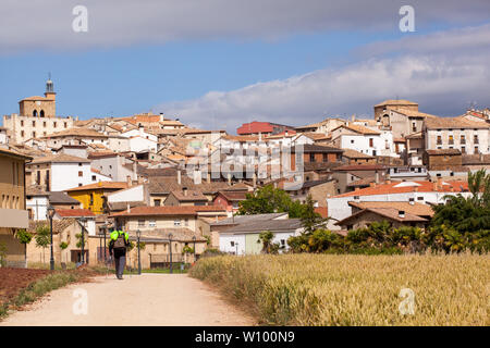 Uomo pellegrino a piedi nella campagna spagnola sul Camino de Santiago la via di San Giacomo che si avvicina al villaggio di Cirauqui Navarra Spagna Foto Stock