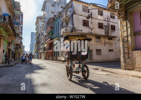 L'Avana, Cuba - 13 Maggio 2019: Noleggio Taxi Driver in bici per le strade di l'Avana Vecchia Città durante un vivace e luminosa mattina di sole. Foto Stock