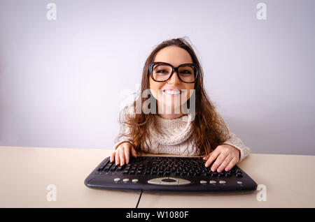 Funny nerd ragazza che lavora sul computer Foto Stock