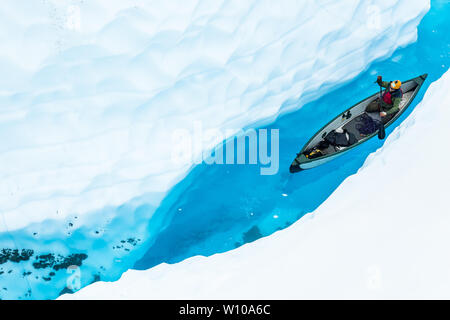 Guardando verso il basso una stretta fessura canyon di ghiaccio a un uomo in una canoa gonfiabile. Foto Stock