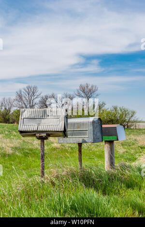 Una fila di tre vecchi contadini in metallo Cassette postali su praterie nelle zone rurali di Saskatchewan, Canada Foto Stock