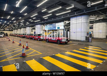 Hong Kong, Cina - 6 Maggio 2018 : Rosso retrò taxi parcheggiato in attesa passeggero con segno attraverso la costruzione di Foto Stock