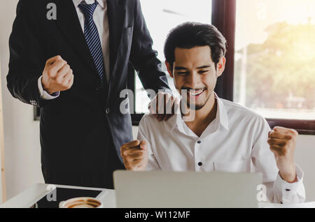 Business man sensazione eccitato con alzata fino a mani che esprimono con successo positivo con il giovane dipendente in sala riunioni a home office company Foto Stock