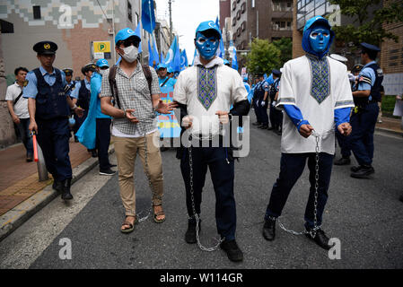 Osaka, Giappone. 29 giu 2019. Gli attivisti uigura usura catene ad una dimostrazione durante il Vertice del G20 di Osaka in Giappone. Credito: Ben Weller/AFLO/Alamy Live News Foto Stock