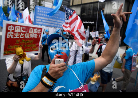 Osaka, Giappone. 29 giu 2019. Un attivista uigura conduce chants pur dimostrando durante il Vertice del G20 di Osaka in Giappone. Credito: Ben Weller/AFLO/Alamy Live News Foto Stock