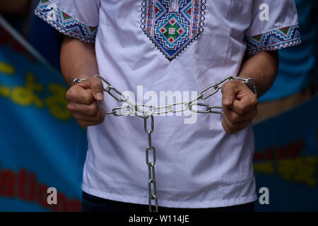 Osaka, Giappone. 29 giu 2019. Un attivista uigura indossa catene ad una dimostrazione durante il Vertice del G20 di Osaka in Giappone. Credito: Ben Weller/AFLO/Alamy Live News Foto Stock