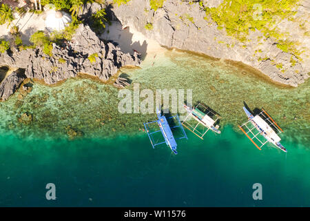 Isola tropicale con spiaggia bianca e barriera corallina.imbarcazioni turistiche nei pressi dell'isola. El Nido Palawan Parco Nazionale delle Filippine. Foto Stock