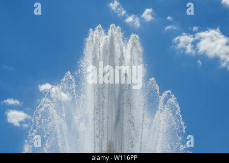 Gli schizzi della fontana contro il cielo blu Foto Stock