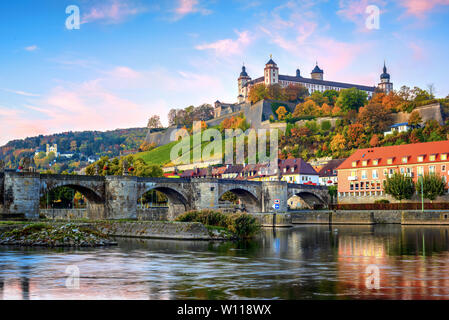 Wurzburg, Baviera, Germania, vista sulla fortezza di Marienberg e il vecchio ponte principale sulla colorata sunrise Foto Stock