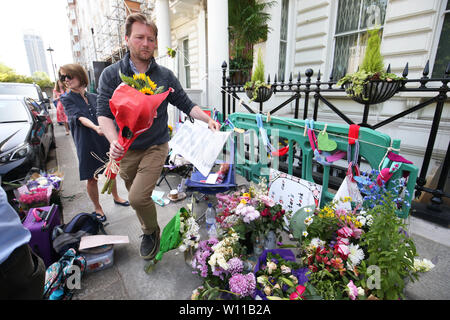 Richard Ratcliffe, il marito di detenuti Nazanin Zaghari Ratcliffe tiene giù omaggi a sinistra al di fuori dell'Ambasciata Iraniana a Knightsbridge, Londra. Ratcliffe oggi ha terminato il suo sciopero della fame dopo la sua moglie in carcere si è concluso il suo sciopero della fame dopo quindici giorni in un carcere Iran. Foto Stock