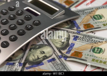 Rendiconti finanziari. Calcolatrice, dollari sui grafici finanziari. Close-up. Il concetto di business Foto Stock