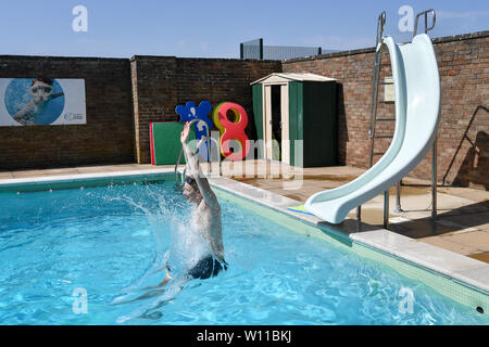 Un nuotatore utilizza la slitta al Lido in Chipping Norton in Oxfordshire, il giorno che potrebbe vedere un nuovo record per una temperatura di giugno nel Regno Unito. Foto Stock