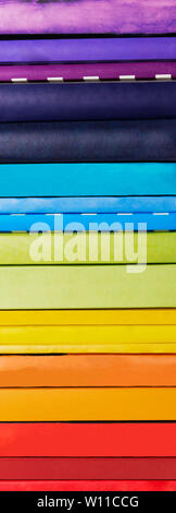 Pila di arcobaleno colorato libri su sfondo bianco Foto Stock