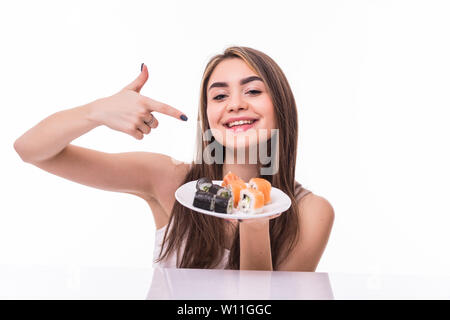 Giovane donna in possesso di un pezzo di sushi con bacchette contro uno sfondo bianco Foto Stock