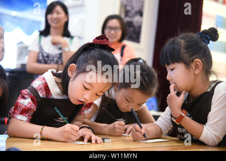 (190629) -- QINGDAO, Giugno 29, 2019 (Xinhua) -- i giovani volontari scrivere a ragazzi che vivono in remoti indigenza zone montuose ad Zhanqiao Bookstore di Qingdao, est della Cina di Shandong, Giugno 29, 2019. Più di trenta ragazzi erano addestrati come volontari in Zhanqiao Bookstore. Durante le vacanze estive, essi saranno impegnati in lettori di orientamento, libri di ordinamento, il benessere pubblico attività e altri lavori all'interno delle loro capacità. In ritorno, sono concesse priorità nel prendere i libri in prestito, con qualche dato a loro come doni. (Xinhua/Li Ziheng) Foto Stock