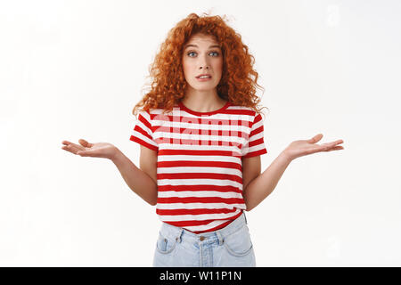 Confuso redhead perplesso curly-ragazza dai capelli non può capire perché il boss orinato scrollare smirking sollevare le sopracciglia incerte mani si sviluppa lateralmente q Foto Stock