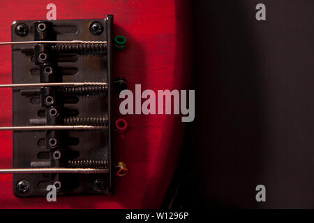 Fondo di un rosso Bass Guitar Mostra i collegamenti a ponte Foto Stock