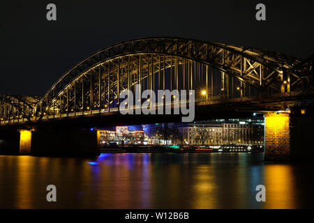 La cattedrale di Colonia e il ponte di Hohenzollern in notturna a Colonia, Germania Foto Stock
