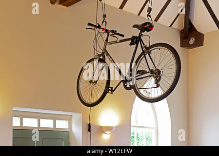 Mens bicicletta essendo memorizzato nei puntoni di una casa Foto Stock